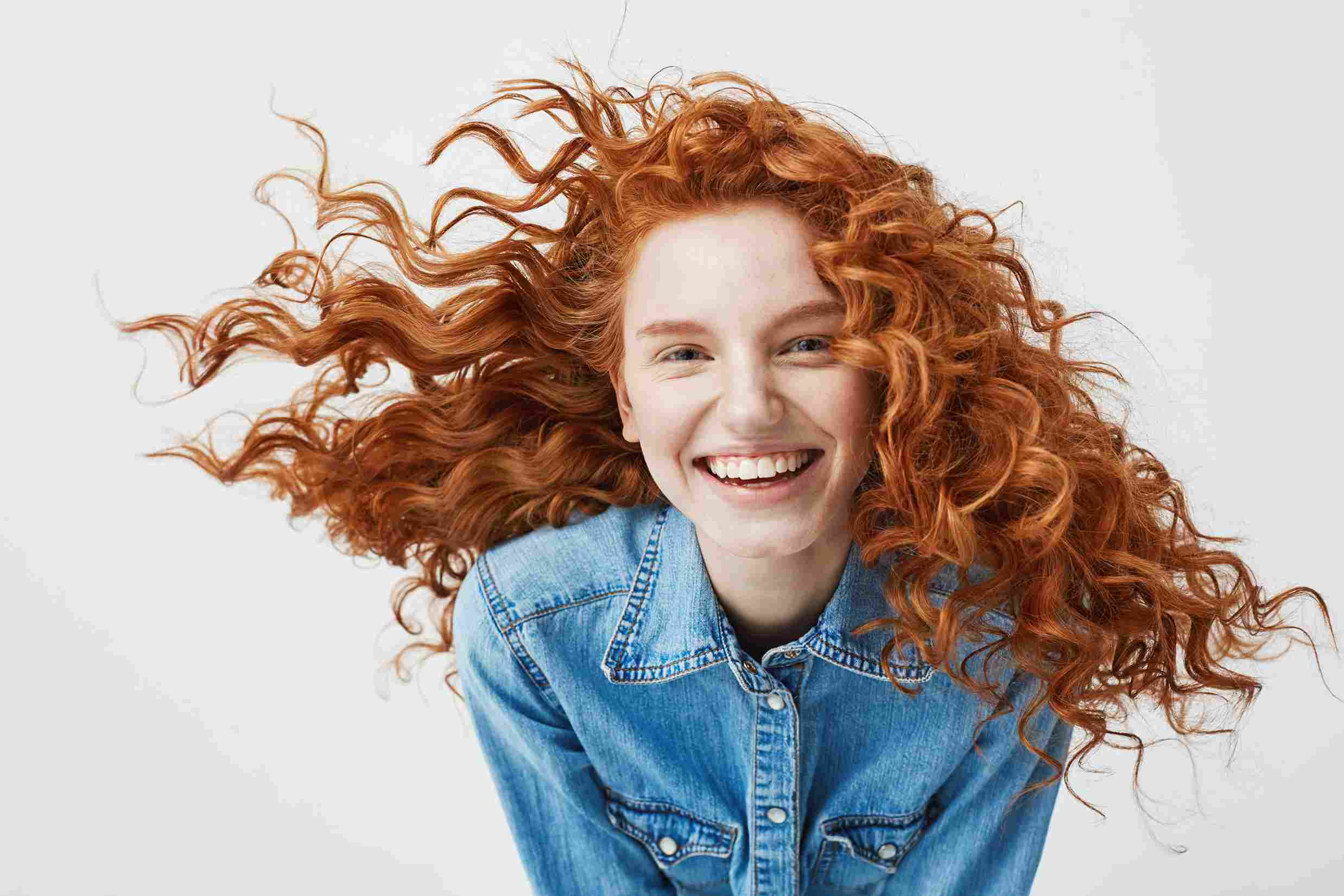 portrait beautiful cheerful redhead woman with flying curly hair smiling laughing 11zon