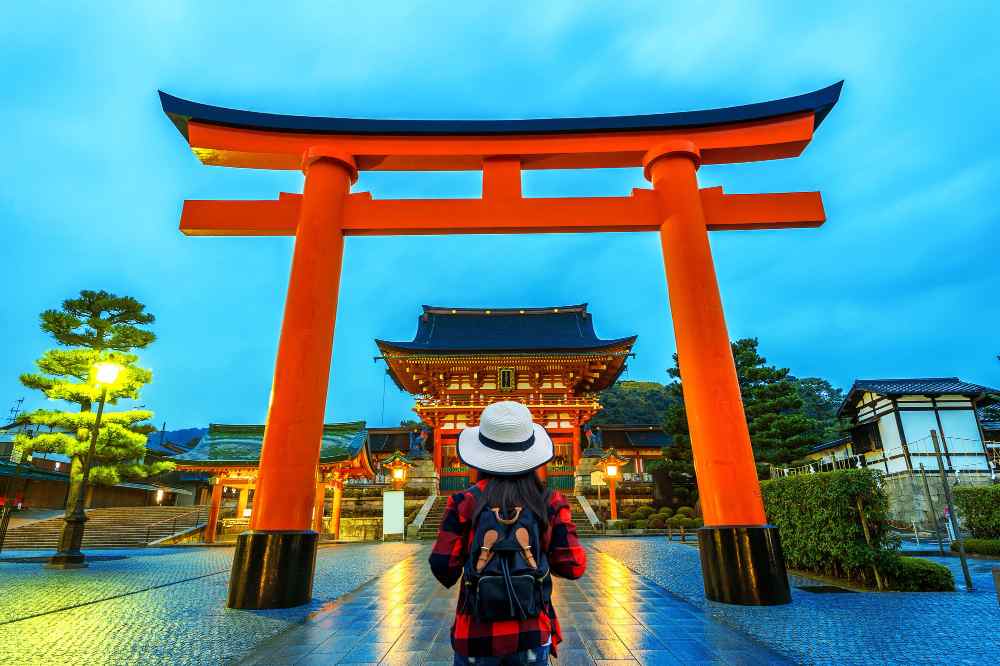 woman traveler with backpack fushimi inari taisha shrine kyoto japan 11zon