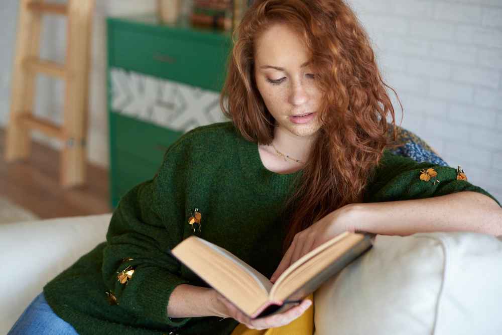focused women reading book living room 11zon